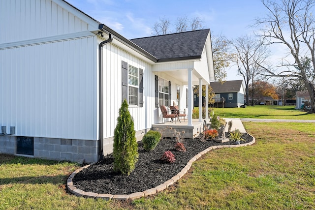 view of side of property featuring a yard and covered porch