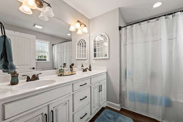 bathroom with hardwood / wood-style floors, vanity, and walk in shower