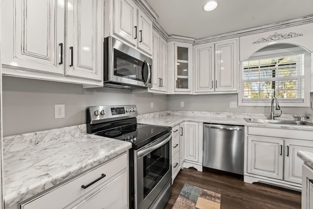 kitchen with stainless steel appliances, white cabinetry, dark wood-type flooring, and sink