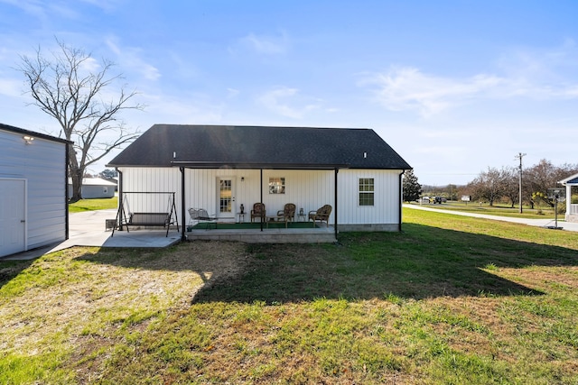 rear view of house featuring a lawn and a porch