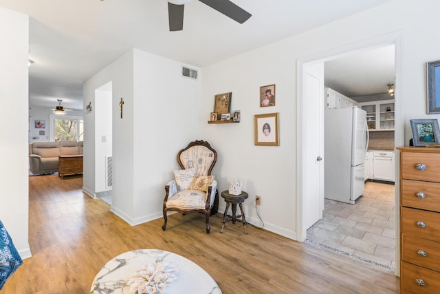 living area with ceiling fan and light wood-type flooring