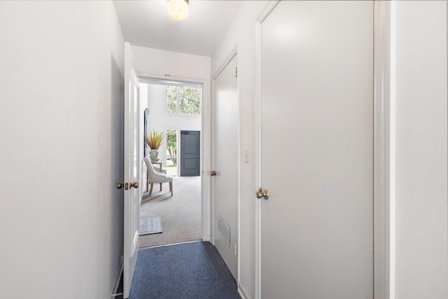 hallway featuring dark colored carpet