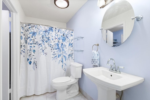 bathroom with tile patterned floors, toilet, curtained shower, and sink