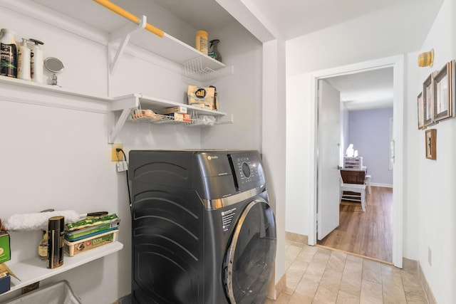 laundry area with washer / clothes dryer and light hardwood / wood-style floors