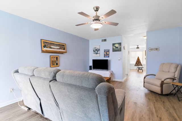 living room featuring ceiling fan and light hardwood / wood-style floors