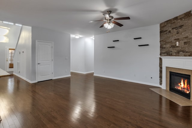 unfurnished living room featuring dark hardwood / wood-style floors, ceiling fan, and a tile fireplace