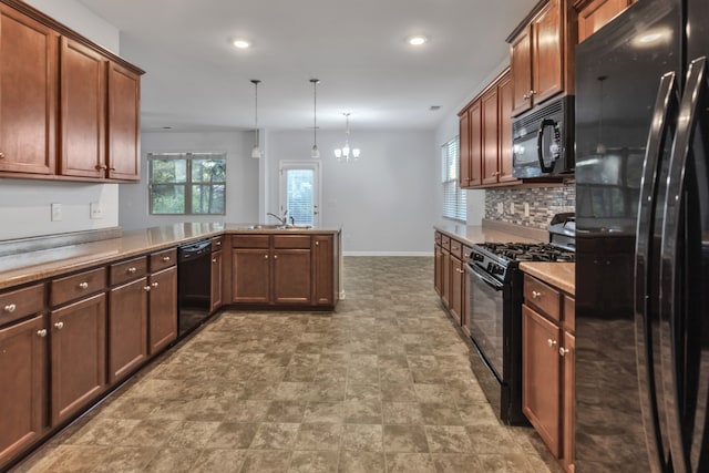 kitchen featuring kitchen peninsula, an inviting chandelier, hanging light fixtures, and black appliances