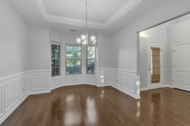 unfurnished dining area featuring dark hardwood / wood-style flooring, a tray ceiling, an inviting chandelier, and crown molding