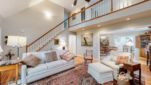 living room with high vaulted ceiling and light hardwood / wood-style floors