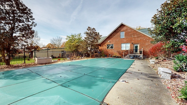 view of swimming pool featuring a hot tub