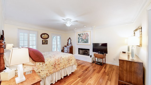 bedroom featuring ceiling fan, ornamental molding, and light hardwood / wood-style flooring