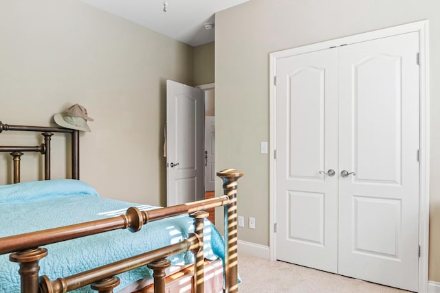 bedroom featuring light colored carpet and a closet