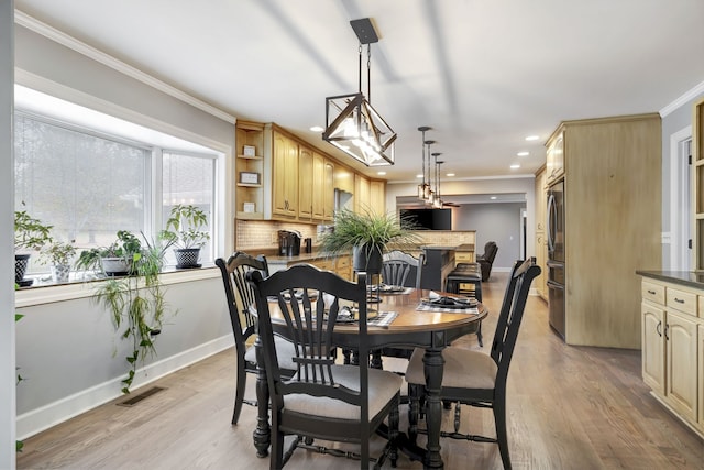 dining area featuring ornamental molding and light wood-type flooring