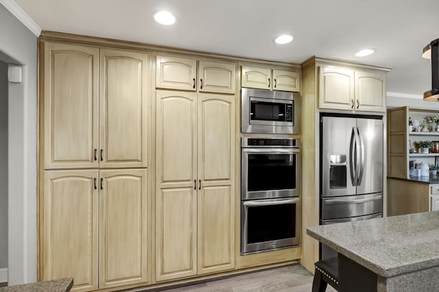 kitchen featuring light brown cabinets, stainless steel appliances, light hardwood / wood-style flooring, and crown molding