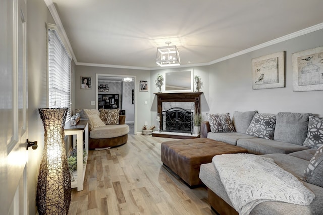 living room featuring light hardwood / wood-style floors, an inviting chandelier, and ornamental molding