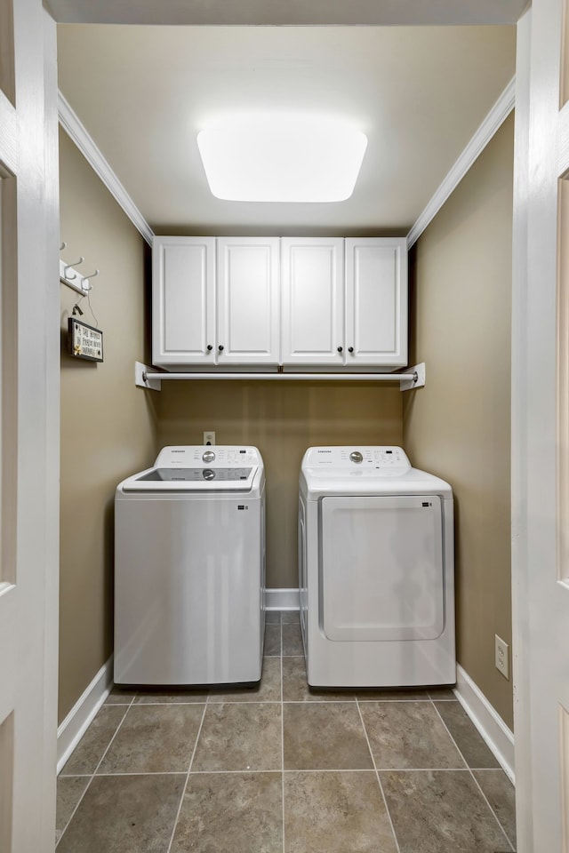 laundry room with tile patterned floors, washer and dryer, cabinets, and ornamental molding