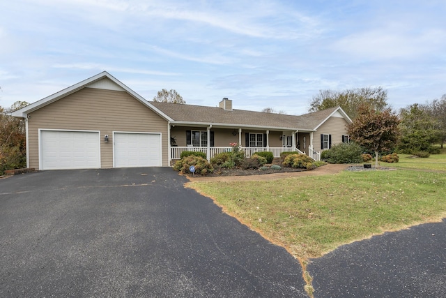 ranch-style house with covered porch, a garage, and a front lawn