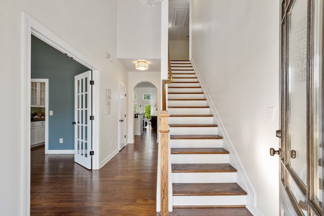 foyer entrance with dark hardwood / wood-style floors and a high ceiling