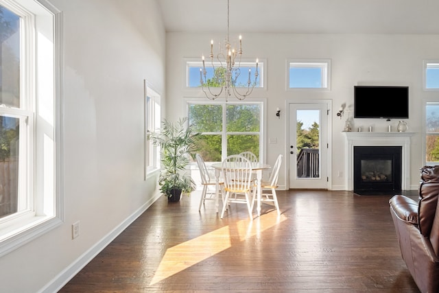 dining space featuring a notable chandelier, dark hardwood / wood-style flooring, and a towering ceiling