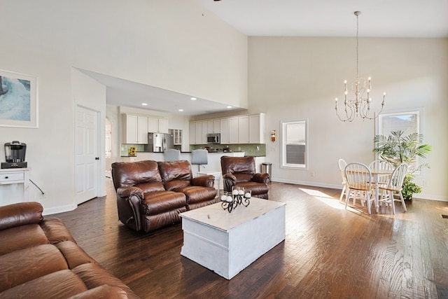 living room featuring a notable chandelier, dark wood-type flooring, and high vaulted ceiling