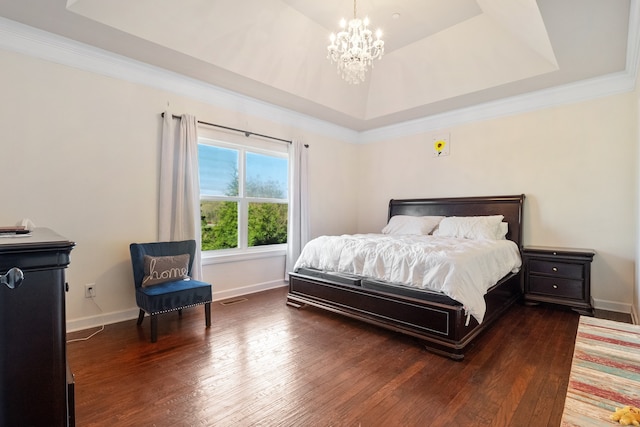 bedroom with a raised ceiling, ornamental molding, dark hardwood / wood-style floors, and a notable chandelier