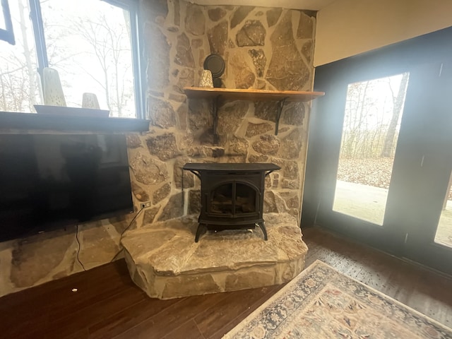 room details with hardwood / wood-style floors and a wood stove