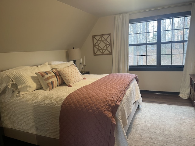 bedroom featuring hardwood / wood-style flooring and vaulted ceiling