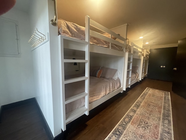 unfurnished bedroom featuring electric panel and dark hardwood / wood-style floors