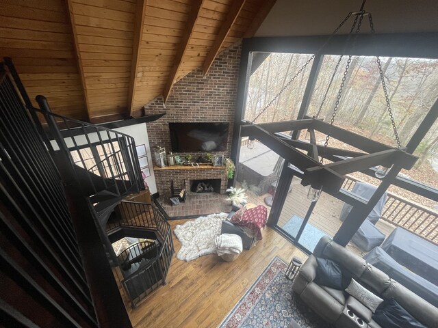 living room with vaulted ceiling with beams, plenty of natural light, wood-type flooring, and wooden ceiling