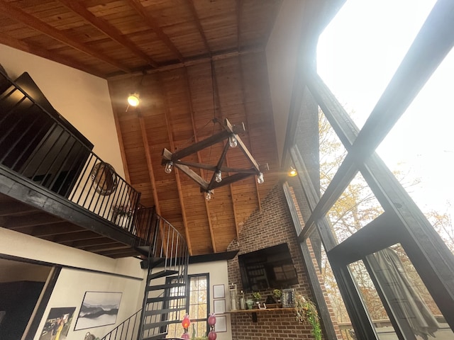 interior space featuring beam ceiling, wood ceiling, and a high ceiling