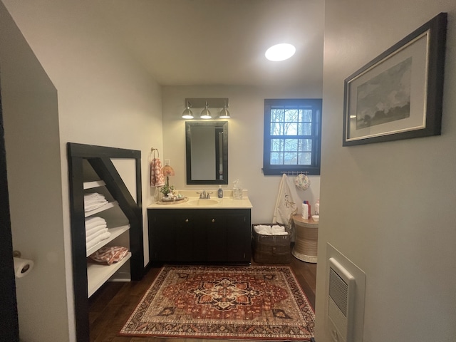 bathroom with wood-type flooring, vanity, and heating unit