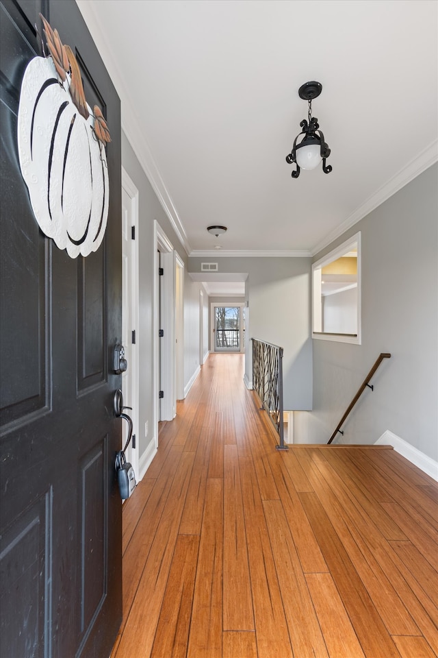 entrance foyer featuring hardwood / wood-style flooring and crown molding