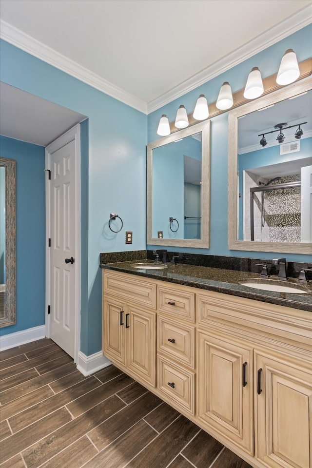 bathroom featuring vanity, crown molding, and a shower