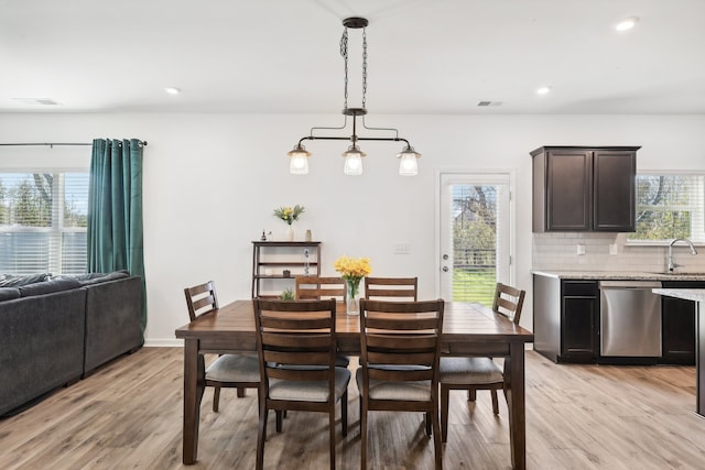 dining area with light hardwood / wood-style flooring, a healthy amount of sunlight, and sink