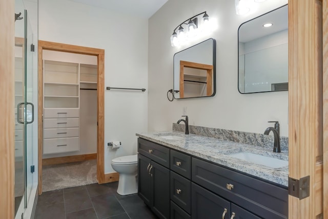 bathroom featuring tile patterned flooring, vanity, toilet, and walk in shower