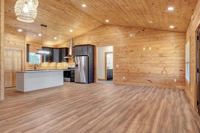 kitchen featuring wall chimney range hood, hanging light fixtures, light hardwood / wood-style flooring, appliances with stainless steel finishes, and wood ceiling