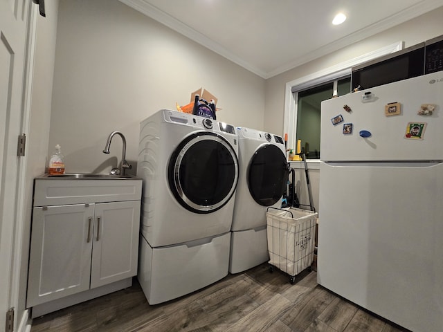 washroom featuring washer and clothes dryer, sink, dark hardwood / wood-style flooring, and ornamental molding