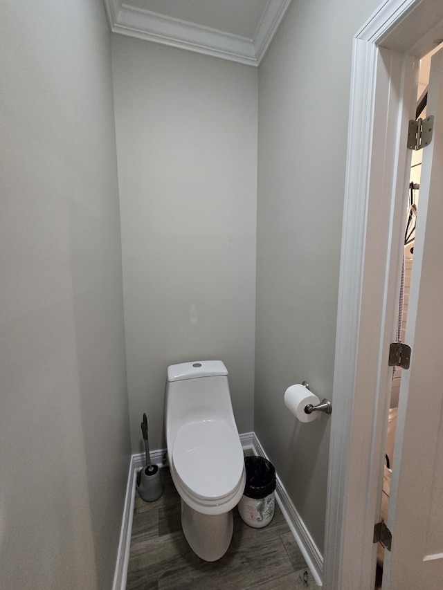 bathroom featuring crown molding, hardwood / wood-style floors, and toilet