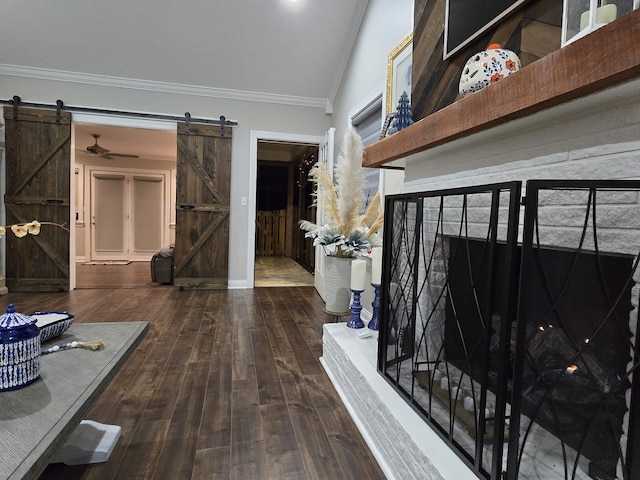 corridor featuring a barn door, wood-type flooring, ornamental molding, and vaulted ceiling