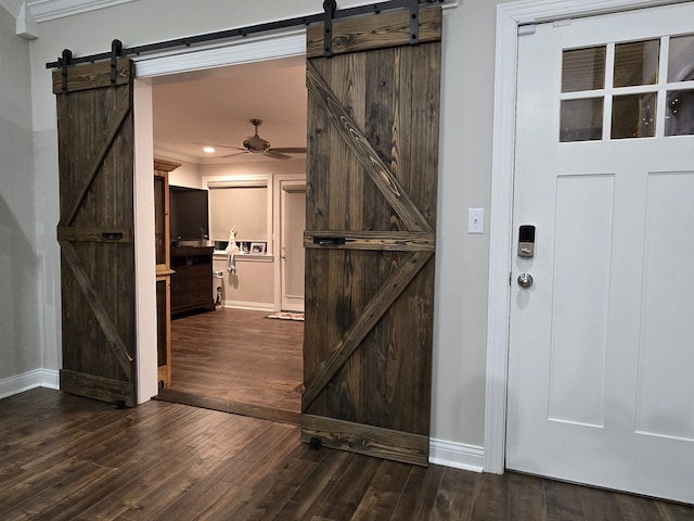 entryway featuring a barn door, ceiling fan, and wood-type flooring