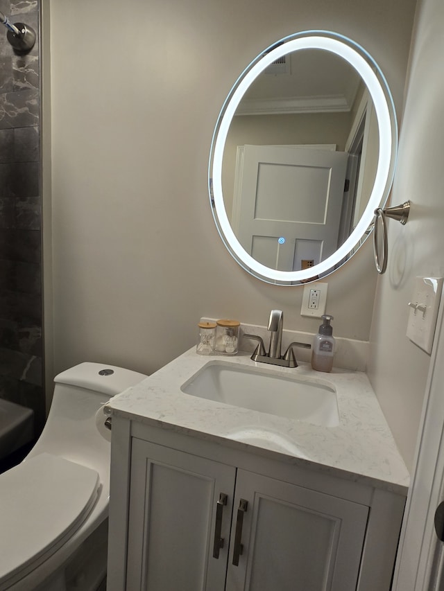 bathroom featuring vanity, ornamental molding, and toilet