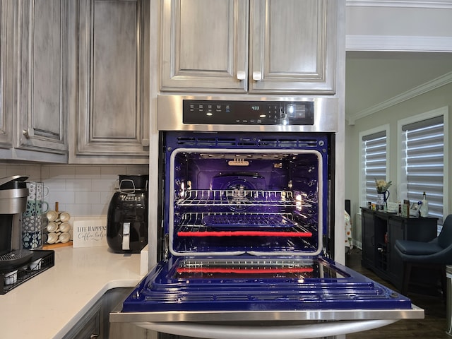 interior details with decorative backsplash and crown molding