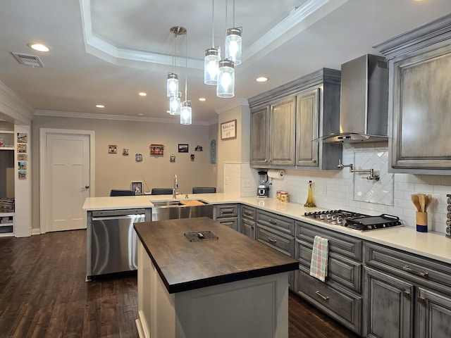 140 Dunn Fall River Rd, Leoma, TN 38468 - kitchen featuring appliances with stainless steel finishes, wall chimney exhaust hood, butcher block counters, a peninsula, and crown molding