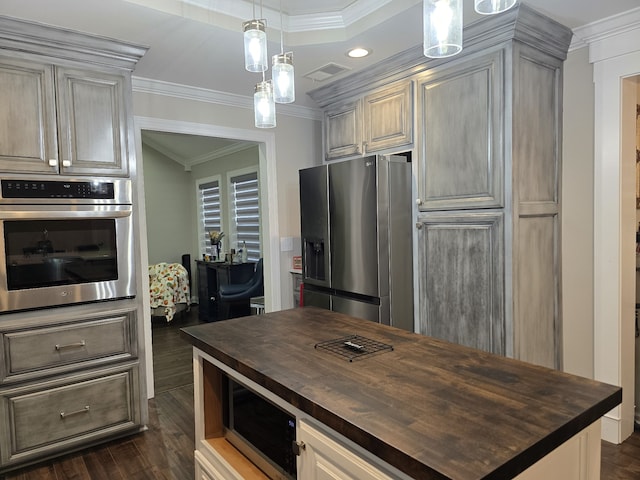 kitchen featuring butcher block counters, dark wood-type flooring, stainless steel appliances, and ornamental molding