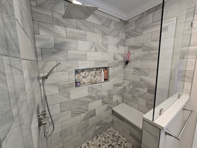 bathroom featuring ornamental molding and tiled shower