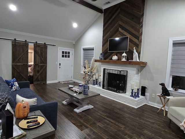 living room with dark wood-type flooring, a brick fireplace, a barn door, high vaulted ceiling, and ornamental molding