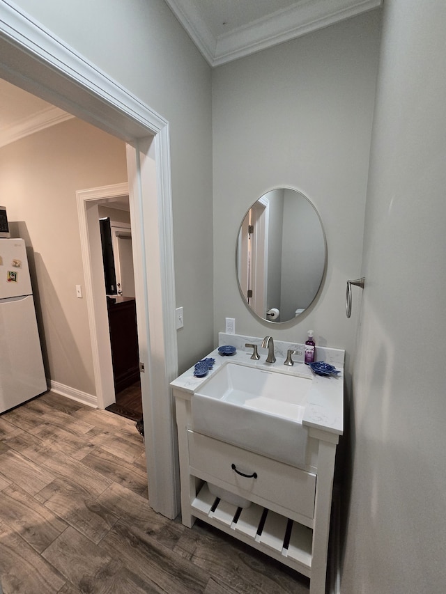 bathroom with hardwood / wood-style flooring, vanity, and crown molding