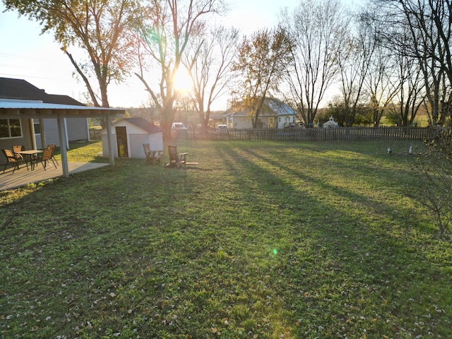 yard at dusk featuring a wooden deck and a storage unit