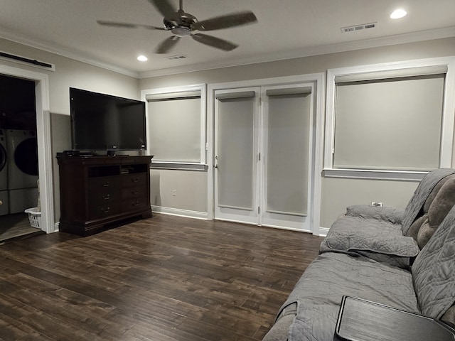 living room with washer and clothes dryer, crown molding, and dark wood-type flooring