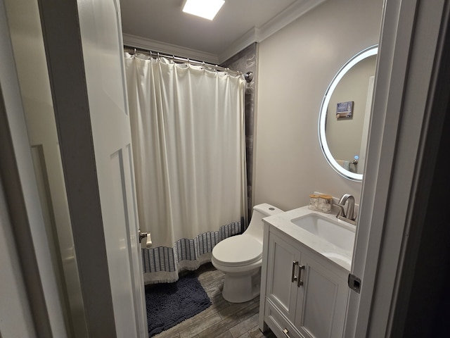 bathroom with hardwood / wood-style floors, vanity, toilet, ornamental molding, and walk in shower